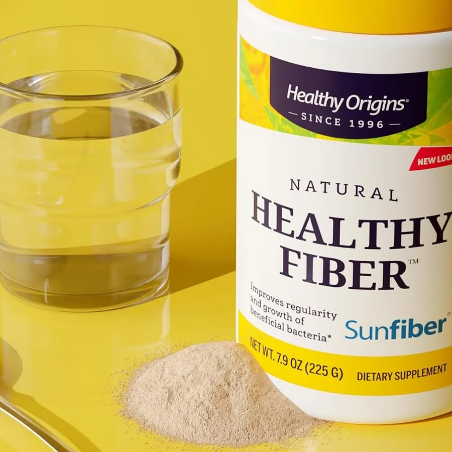 Healthy Origins Healthy Fiber tub containing Sunfiber, beside a glass of water, a spoon and a small pile of powder